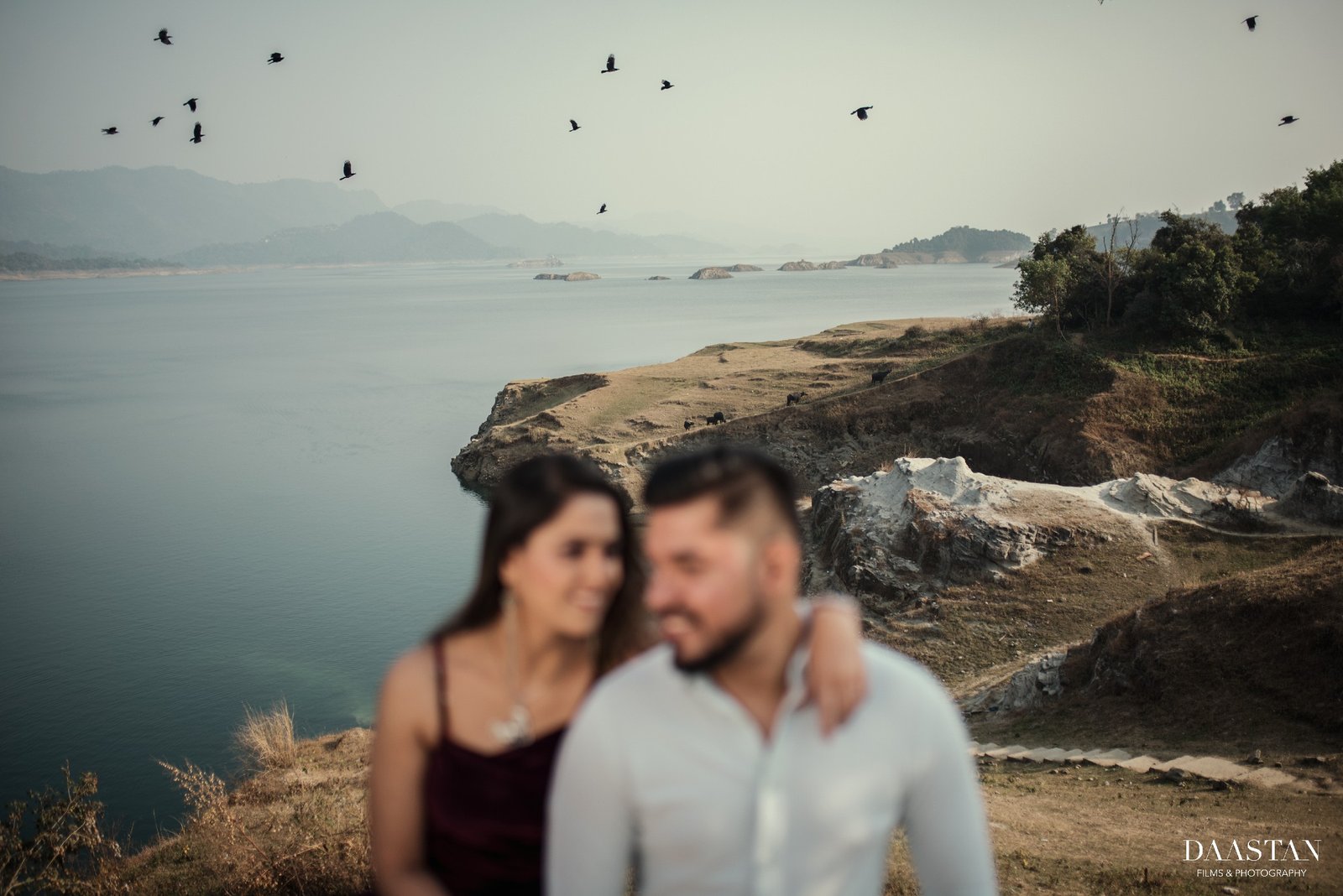 Couple on beach rocks during outdoor pre-wedding shoot, Indian destination couple photography