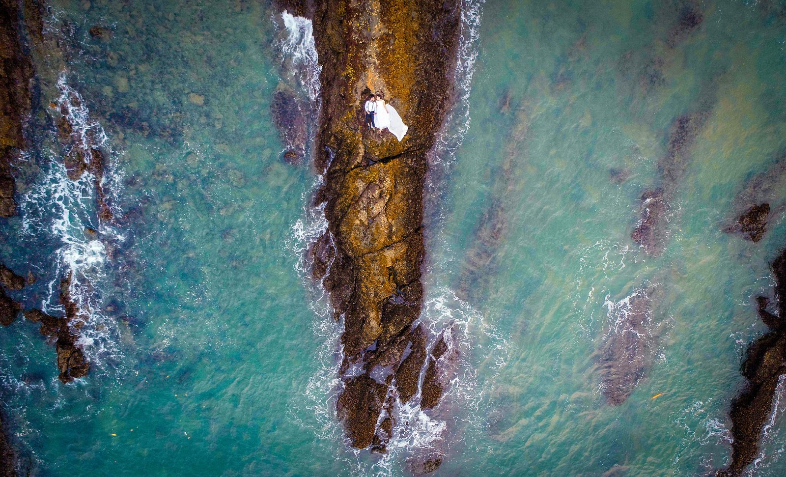 Aerial drone shot of couple at lake during pre-wedding shoot, cinematic Indian wedding photography