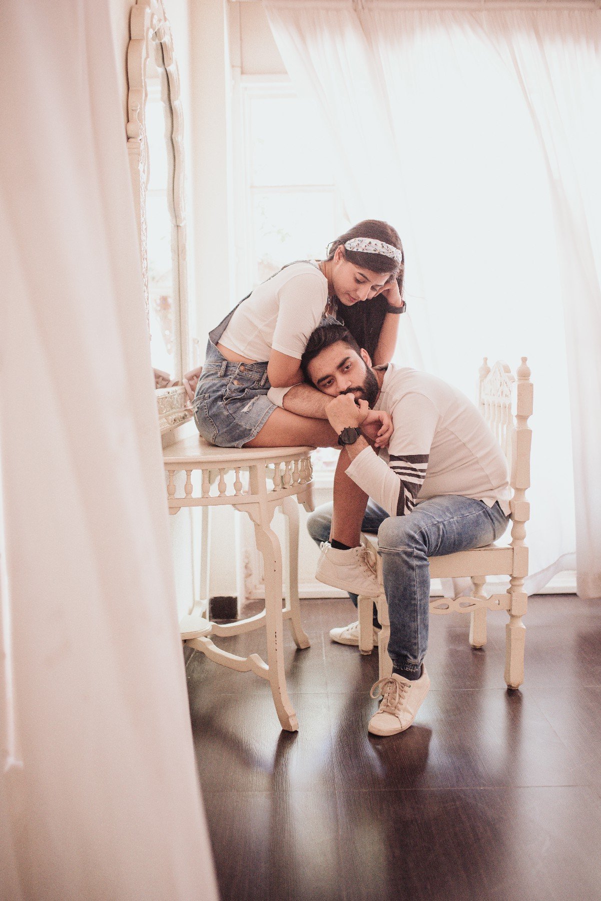 Couple in romantic window light during indoor pre-wedding shoot, Indian photography
