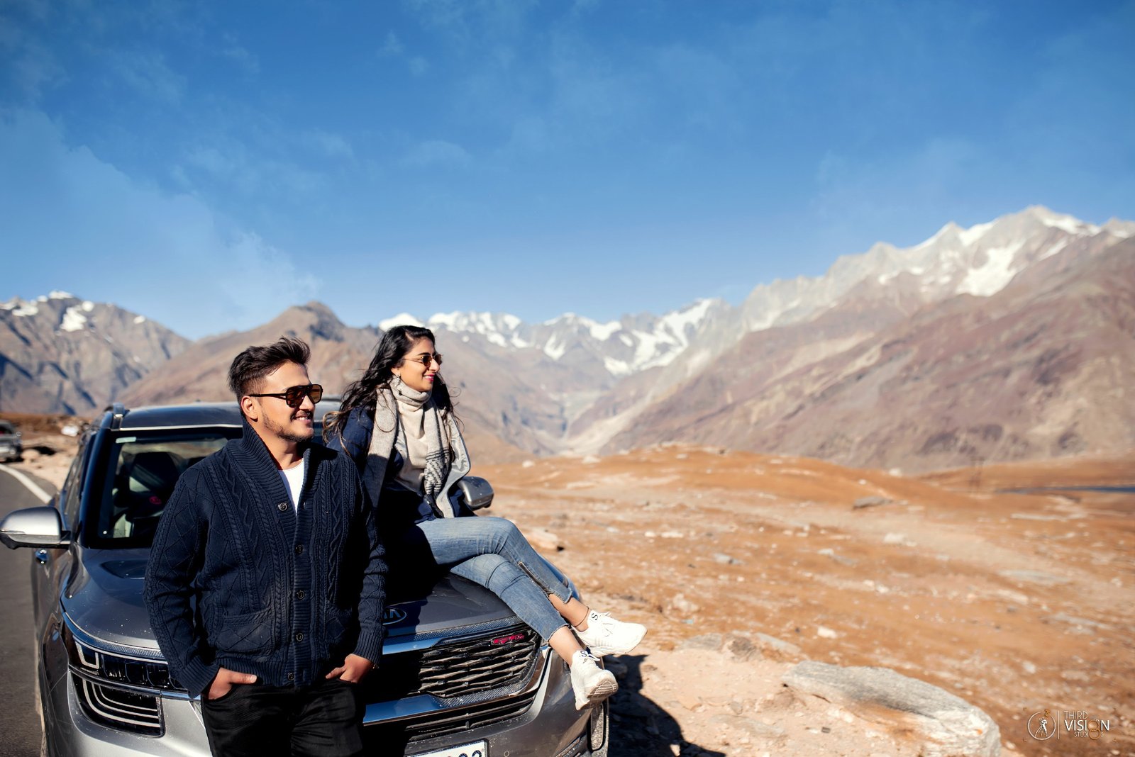 Couple with car on Leh mountain road during pre-wedding shoot, destination Indian photography