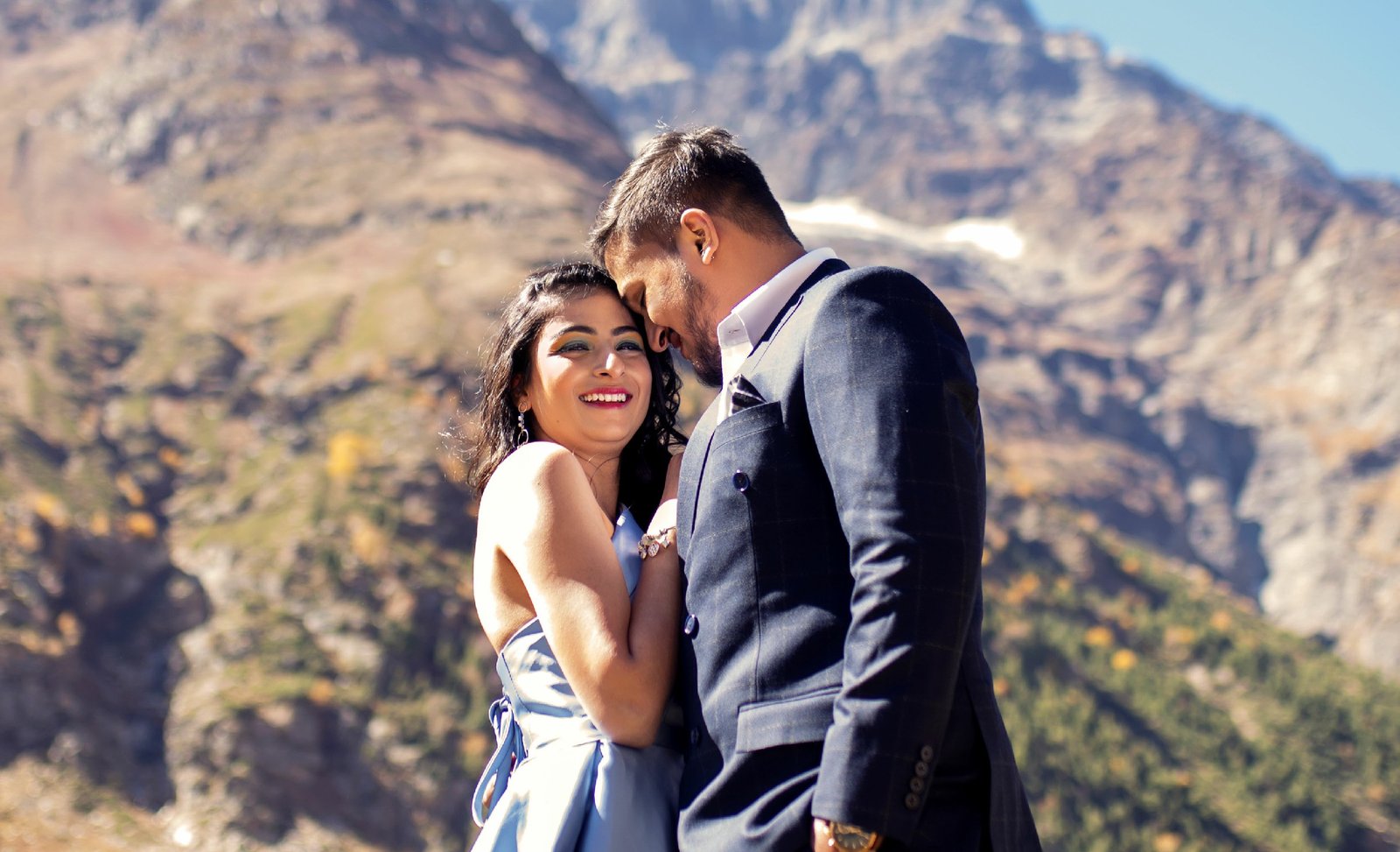 Couple embracing in mountain landscape during pre-wedding shoot, outdoor Indian photography
