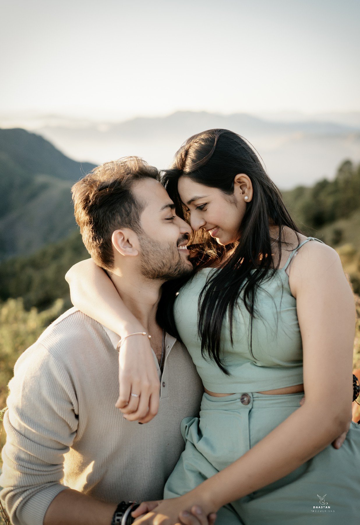 Couple hugging in mountain landscape during outdoor pre-wedding shoot, Indian photography