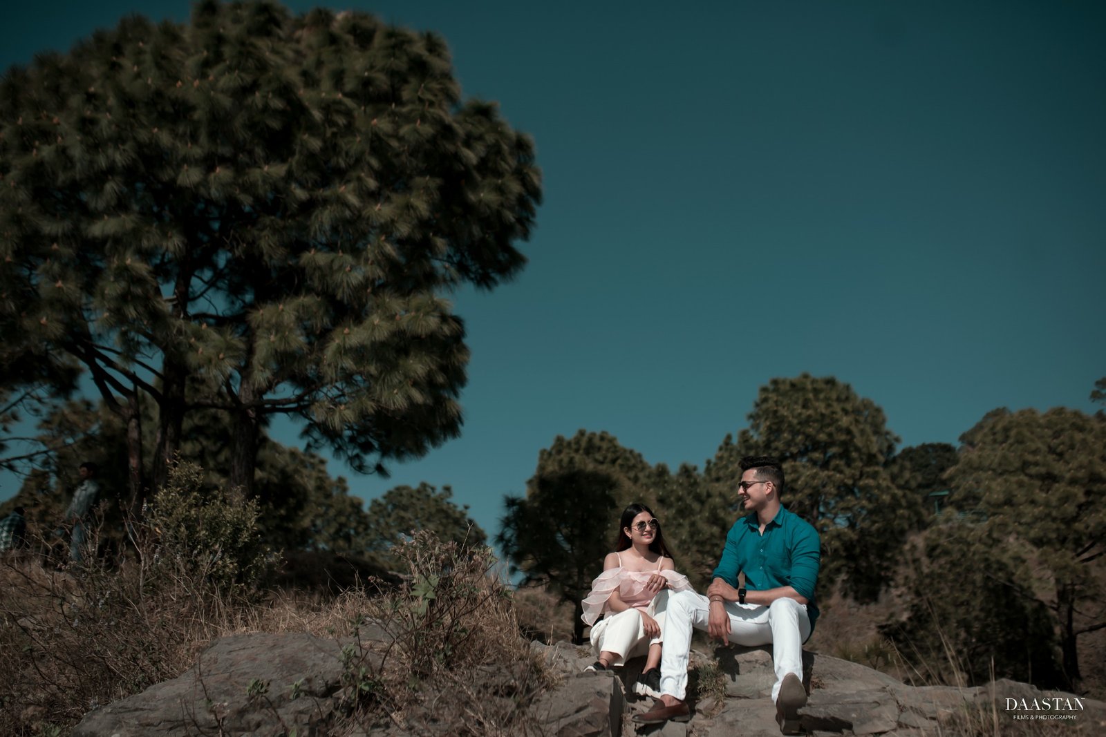 Couple sitting in mountain landscape during outdoor pre-wedding shoot, Indian couple photography