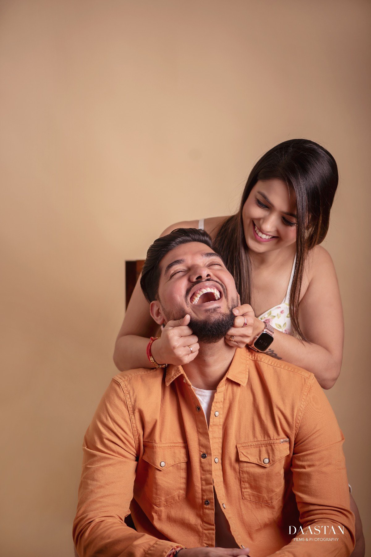 Couple in coordinated orange outfits during studio pre-wedding shoot India