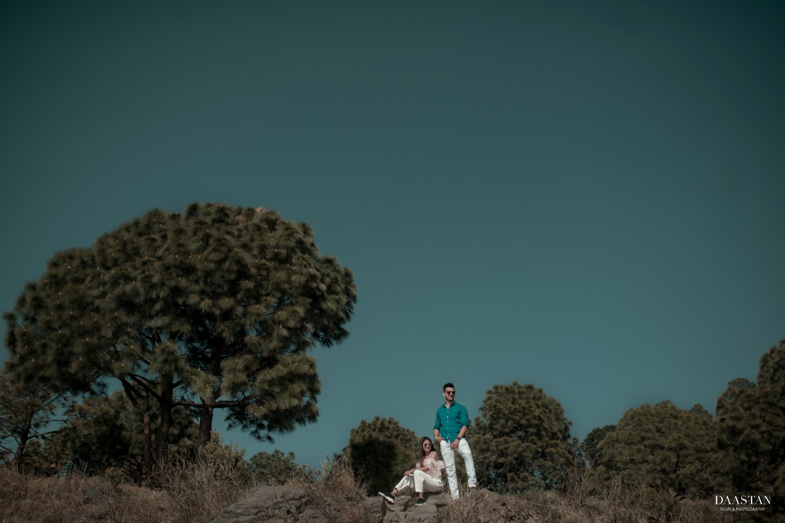 Couple at cottage with teal sky during outdoor pre-wedding shoot, Indian couple photography