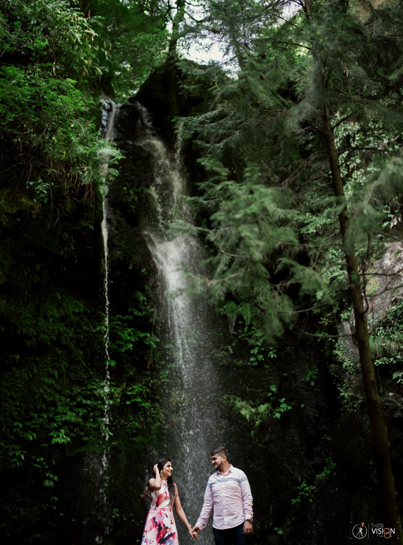 Couple in forest with waterfall during outdoor pre-wedding shoot, Indian couple photography