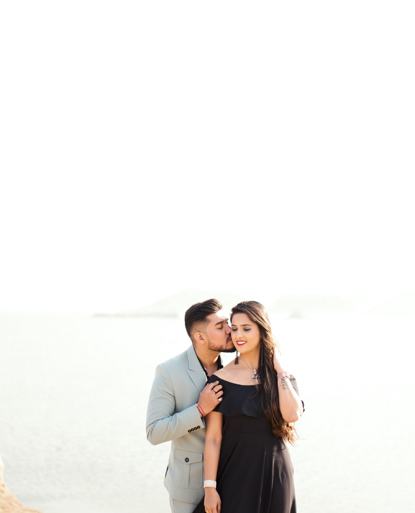 Couple in white minimal studio pre-wedding portrait, clean Indian couple photography